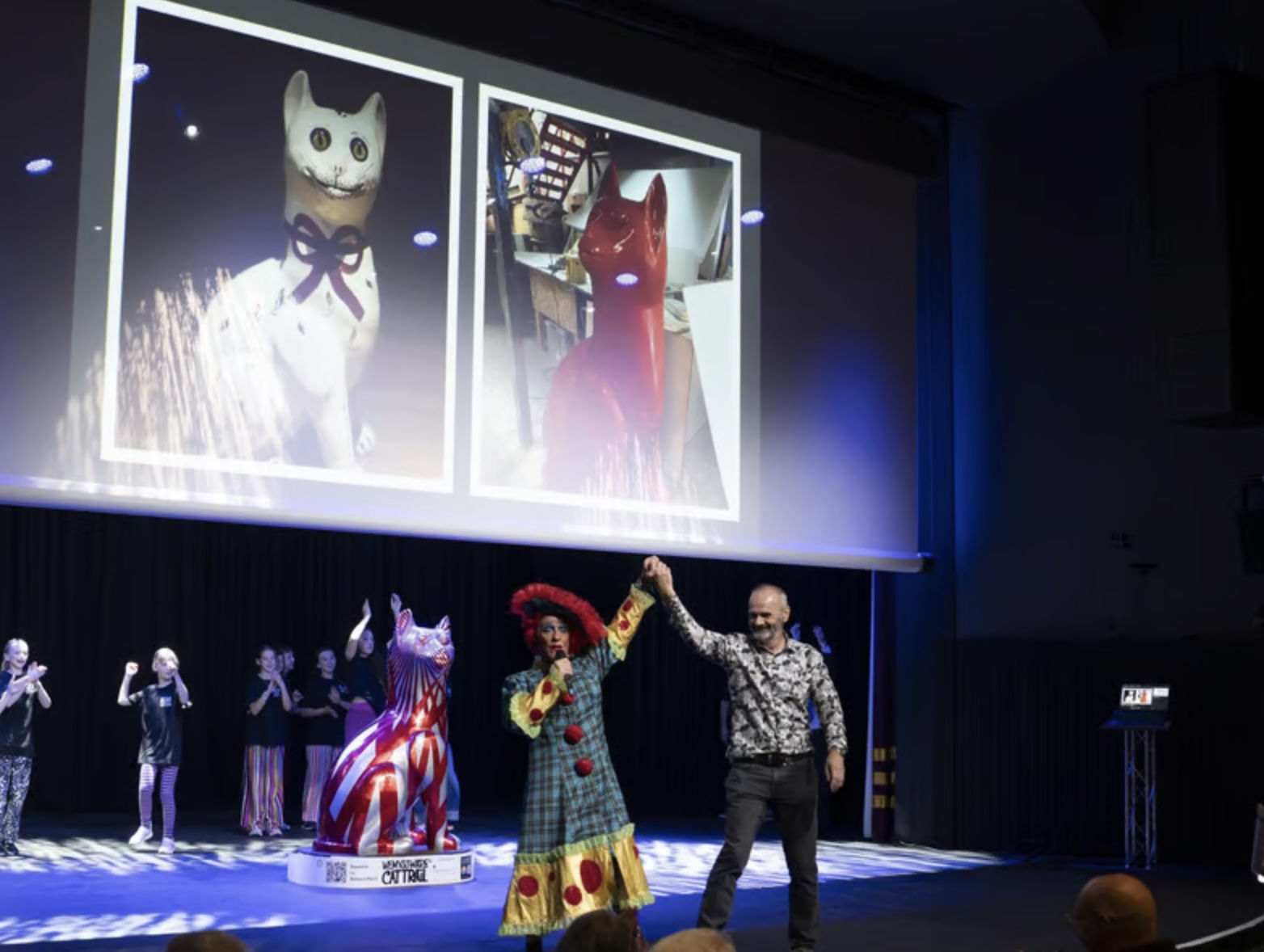 Kirkcaldy Lottery director Gordon Povey dances with panto dame Billy Mac alongside the giant cat sculpture, Sweetie, and kids